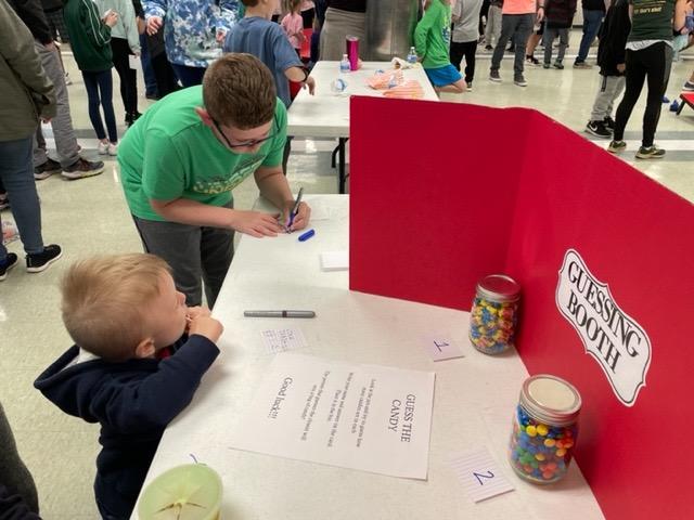 3rd-grader Cooper Bost and his friend take a shot at guessing how many pieces of candy are in the jars