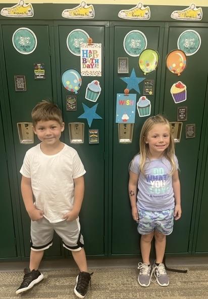 Kindergartners Matthew Kobulinsky and Rowyn Larry stand in front of their birthday lockers