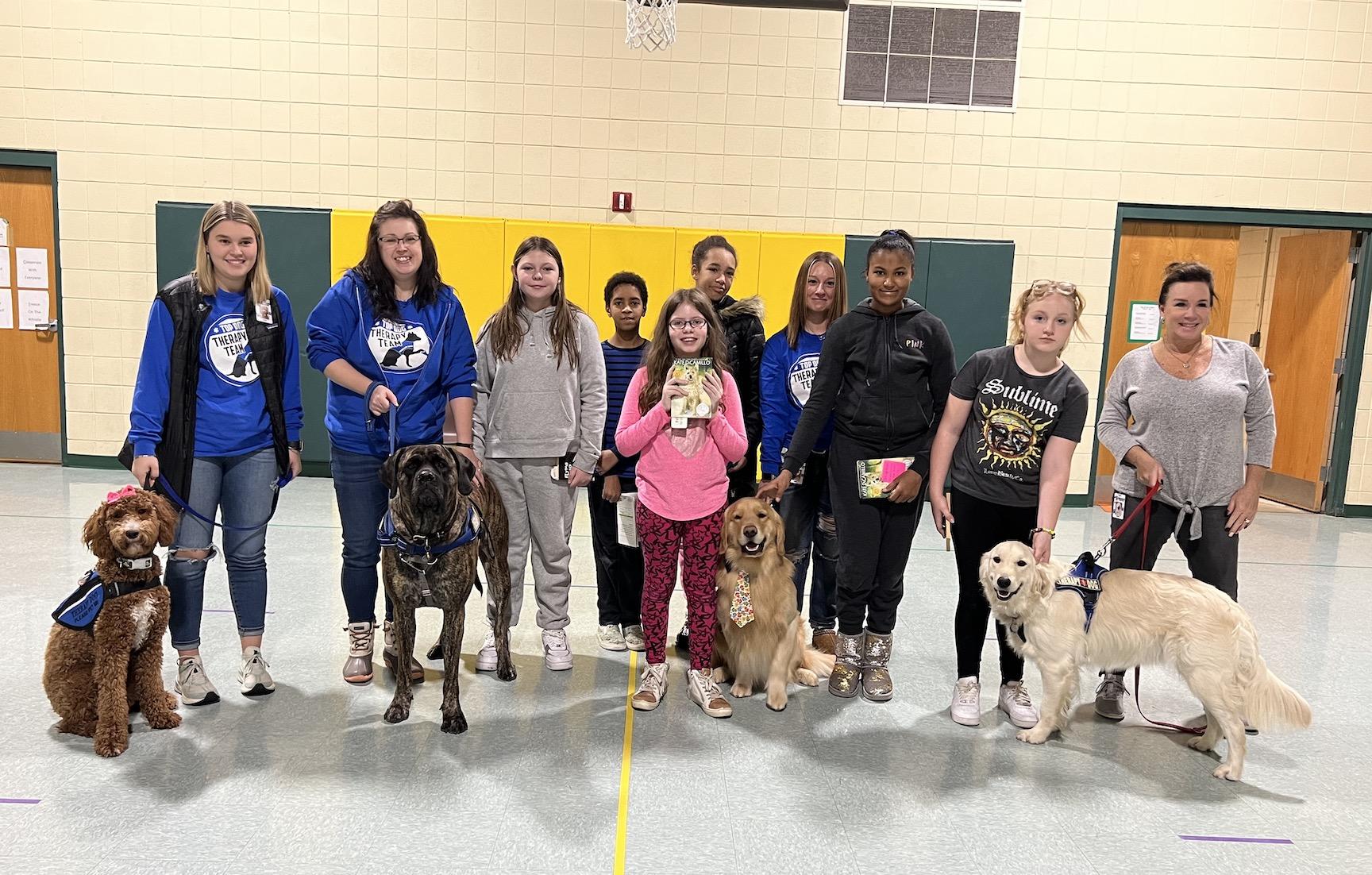 Some of the 4th and 5th-grade students join the dogs and their handlers during the visit