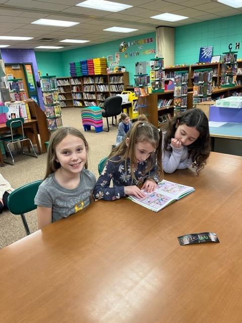 4th-graders Ava Kelley and Aria O’Donnell read with 1st-grader Isabella DiBernardo (center)